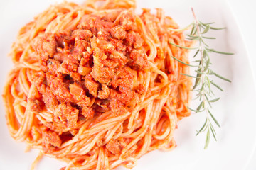 Spaghetti bolognese on a plate	 decorated with a rosemary twig
