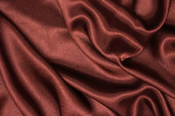 Smooth elegant brown silk or satin luxury cloth texture can be used as abstract background. Crumpled fabric Twisted at the side.