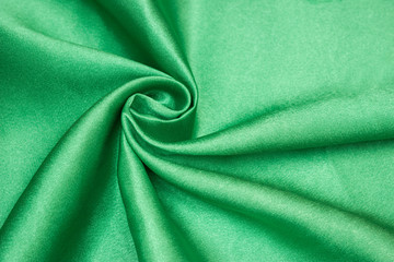 Smooth elegant green silk or satin luxury cloth texture can be used as abstract background. Crumpled fabric Twisted at the side.