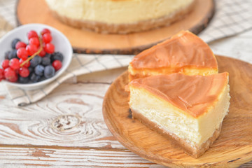 Plate with pieces of tasty cheesecake on table