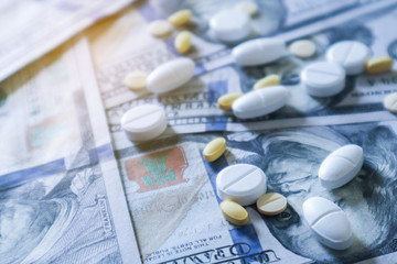medicine pill on 100 dollar banknote background.Healthcare insurance and medical treatment cost concept