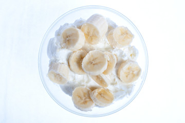 Fototapeta na wymiar Glass bowl with yogurt and slices of a banana