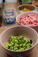 Diced cucumber and ham in pink bowls