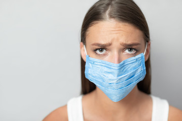 Unhappy Girl Wearing Mask During Pandemic Posing Over White Background