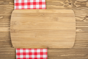 Red checkered tablecloth and wooden spoon for cooking and baking. Background with copy space. Horizontal.