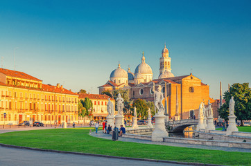 Prato della Valle square in historical city centre of Padua (Padova), elliptical square with green island at the center, small canal with statues, Abbey of Santa Giustina church, Veneto Region, Italy