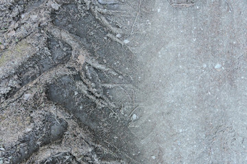 grauer Boden einer Straße auf dem das Relief eines Reifens eingedrückt ist und sich eine Spur gebildet hat welches man als Hintergrund mit Struktur verwenden kann