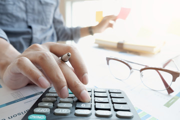 businessman or accountant hand working on calculator to calculate financial data report,...