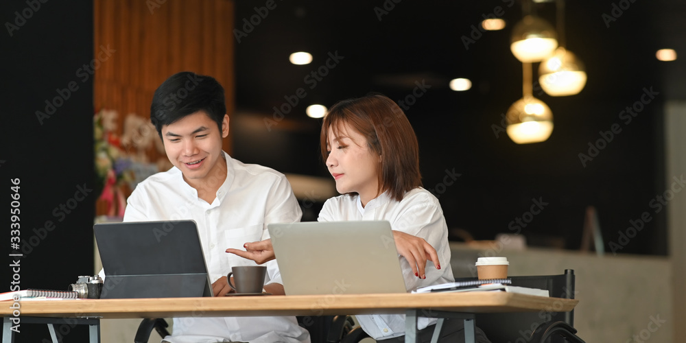 Poster photo of website administrator team working with computer tablet and laptop while sitting together a
