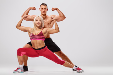 Young sporty couple bodybuilders training together and showing biceps