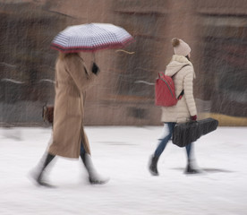 Busy city people going along the street in winter snowy day