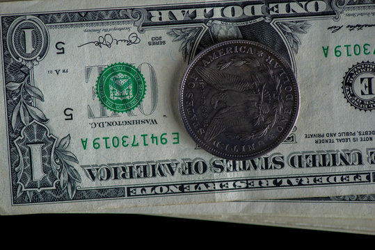 A bundle of banknotes of US dollars on a dark background. Photographed close-up.