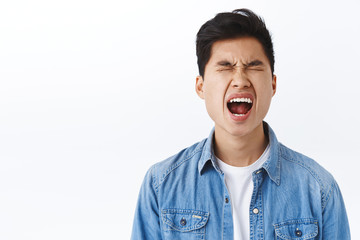 Portrait of silly asian young man whining like baby, crying and screaming complaining on cruel...