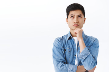 Portrait of thoughtful smart asian man thinking, male student solving puzzled, look up complicated...