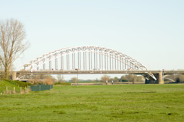 Waalbrug over the river the Waal, with in the foreground a meadow in Nijmegen, Netherlands