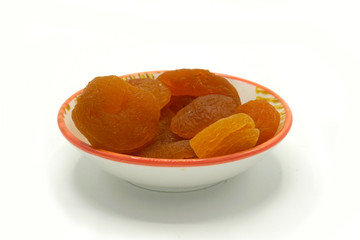 Dried apricots on a ceramic saucer isolated on white background. Energy and fiber natural source. Dieting food.