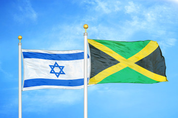 Israel and Jamaica two flags on flagpoles and blue cloudy sky