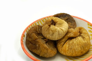 Dried figs on a ceramic saucer isolated on white background. Energy and fiber natural source. Dieting food.