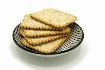 Dried fruits and digestive biscuits on a ceramic saucer isolated on white background. Energy and fiber natural source. Dieting food.