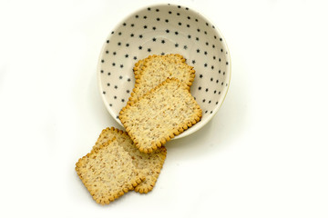 Dried fruits and digestive biscuits on a ceramic saucer isolated on white background. Energy and fiber natural source. Dieting food.