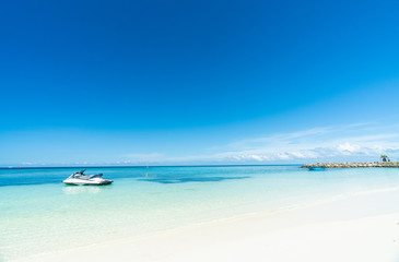 Fototapeta na wymiar Beautiful tropical beach and blue sky in Maafushi Island, Maldives with jet ski