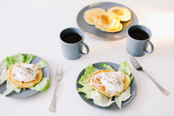 Healthy nutritious tasty breakfast. Pancakes, poached egg on ceramic plate and coffee cup. table setting. food photo. good morning