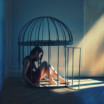 Young woman sitting in cage