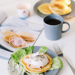 Healthy nutritious tasty breakfast. Pancakes, poached egg on ceramic plate and coffee cup. table setting. food photo. good morning