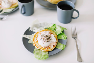 Healthy nutritious tasty breakfast. Pancakes, poached egg on ceramic plate and coffee cup. table setting. food photo. good morning