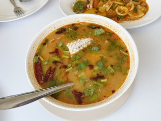 Spicy fish soup flavored with lemongrass and lime served on table
