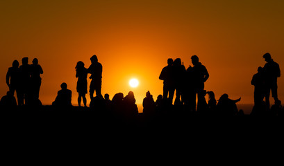 Fototapeta na wymiar Silhouettes of people looking at sunset in Algarve