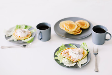 Healthy nutritious tasty breakfast. Pancakes, poached egg on ceramic plate and coffee cup. table setting. food photo. good morning
