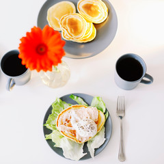 Healthy nutritious tasty breakfast. Pancakes, poached egg on ceramic plate and coffee cup. table setting. food photo. good morning