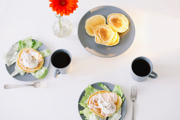 Healthy nutritious tasty breakfast. Pancakes, poached egg on ceramic plate and coffee cup. table setting. food photo. good morning