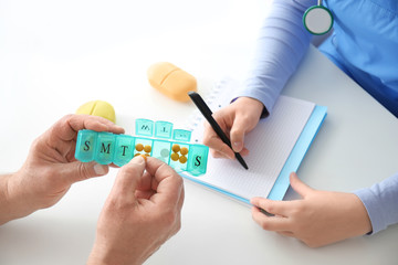 Doctor giving pills to patient in clinic