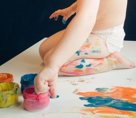 The little boy's feet are stained with paint