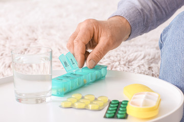Obraz na płótnie Canvas Senior man taking pills at home, closeup