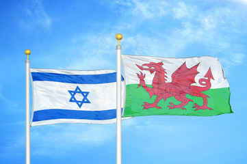 Israel and Wales two flags on flagpoles and blue cloudy sky