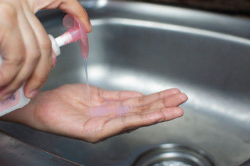 Woman pressing liquid soap antibacterial on her hand for washing hand to against infection...