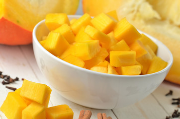 Bowl of chopped pumpkin, cloves and cinnamon prepared for compote.