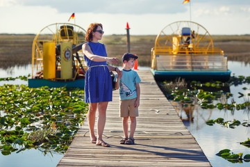 Young mother with her little son on an airboat tour. The Everglades are a natural region of wetlands in the southern portion of the U.S. state of Florida, USA. - 333962078