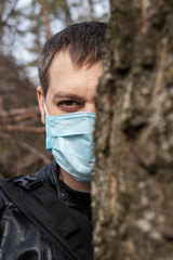 A man in a medical mask in the forest