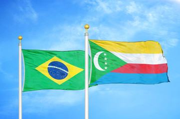 Brazil and Comoros two flags on flagpoles and blue cloudy sky