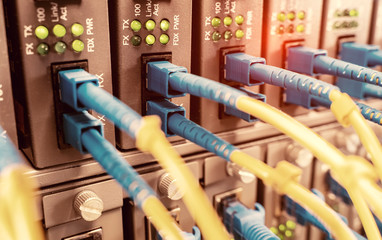 Fototapeta na wymiar Fiber Optic cables connected to optic ports and UTP, Network cables connected to ethernet ports