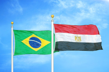 Brazil and Egypt two flags on flagpoles and blue cloudy sky
