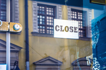 The sign CLOSE on the window of the city store.