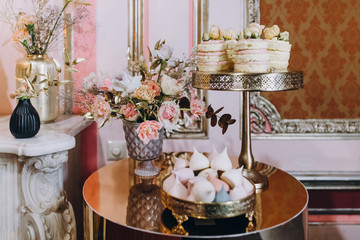 candy bar, sweets, sweets, chocolate, lollipops, cakes and macaroons are laid out on beautiful trays and decorated with flower arrangements