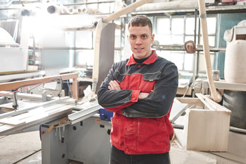 Smiling Engineer worker on the background of an automated manufacturing furniture factory, modern production technologies