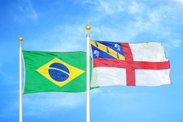 Brazil and Herm two flags on flagpoles and blue cloudy sky