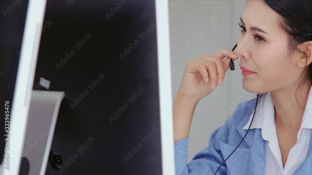 Poster customer support agent or call center with headset works on desktop computer while supporting the cu